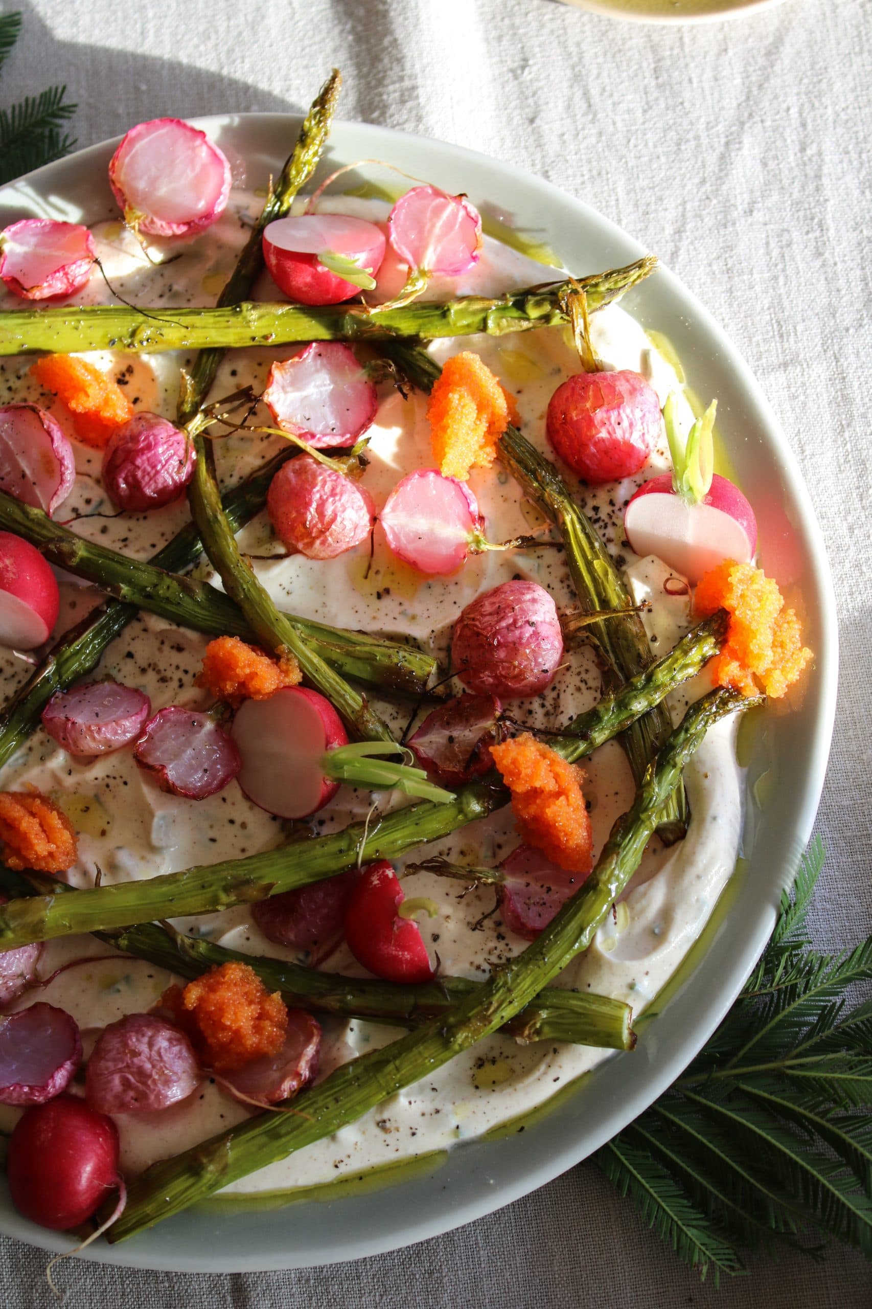 Krämig dip med brynt smör och gräslök serverad i skål med löjrom, rostade rädisor och sparris samt krispiga snacks runtom.